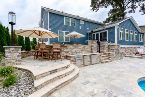 Custom outdoor grill and pizza oven in backyard makeover by Ashton Group at the Beach in Rehoboth Beach, Delaware.