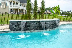 Curved water feature in concrete pool