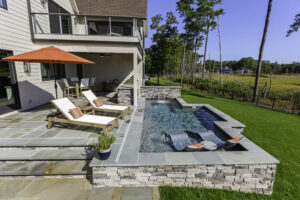 Plunge pool with tanning ledge, spa jets, and waterfall for privacy
