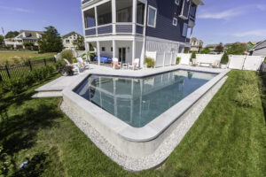 Custom geometric concrete pool with sandblasted marble pavers