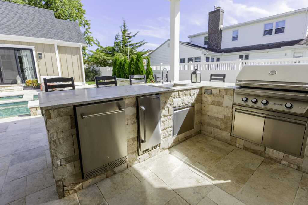 Outdoor kitchen with natural stone veneer and ice maker
