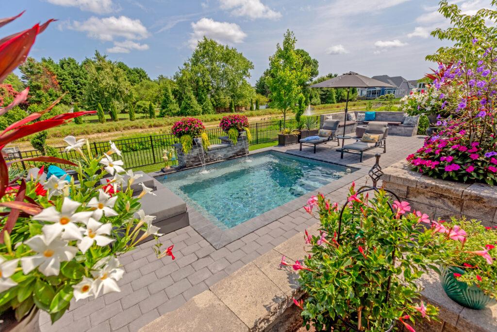 luxury custom plunge pool with beautiful landscaping, water fall feature and seating area with a fire pit all aspects chosen during the design process