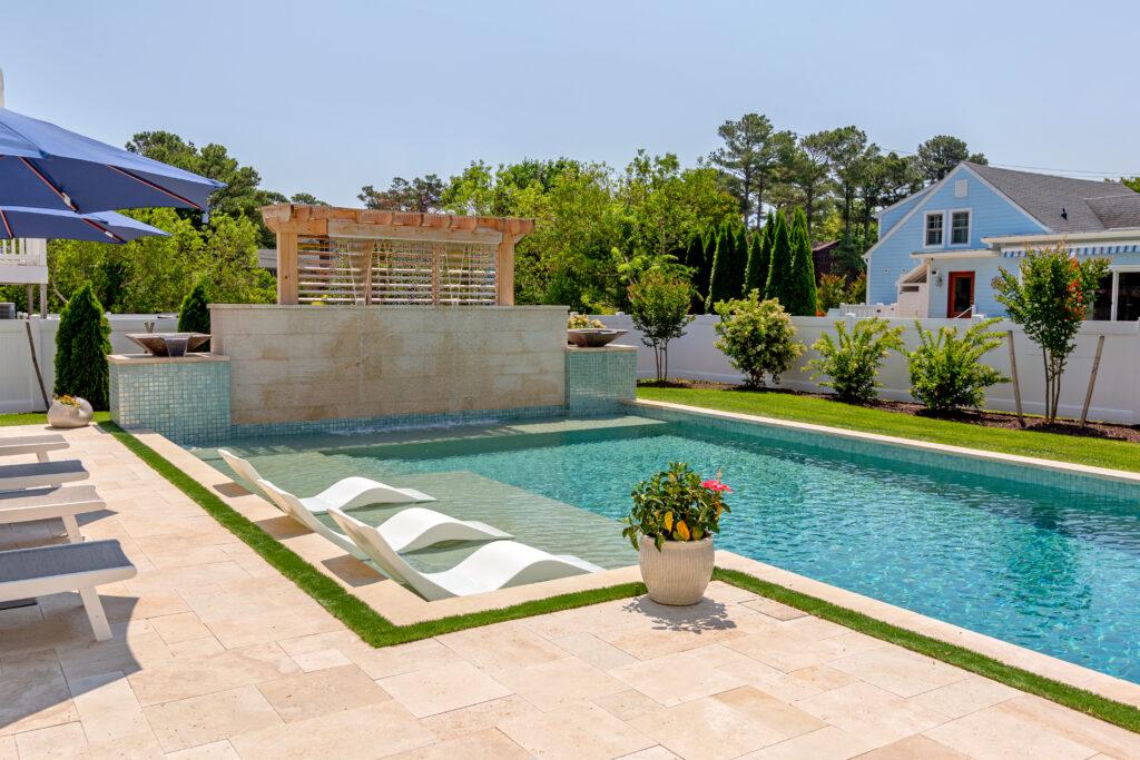 A custom Gunite Pool with tanning ledge, waterfall feature, with ledge loungers