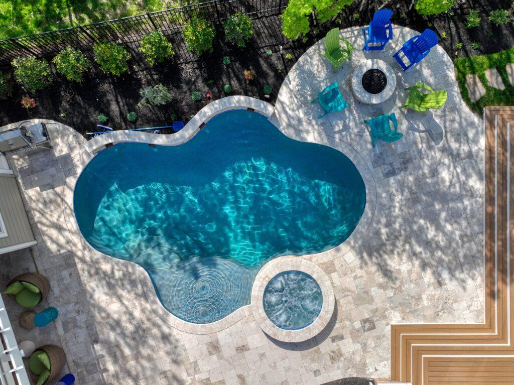 aerial view of custom concrete pool with custom spa and fire pit